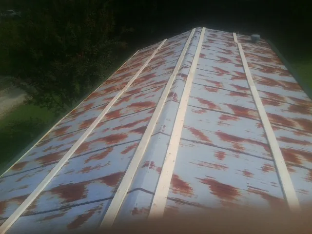 Rusted metal roof panels with new wood purlins before replacement — Storm Damage Roof Repair in Osterville by Roofing Brothers