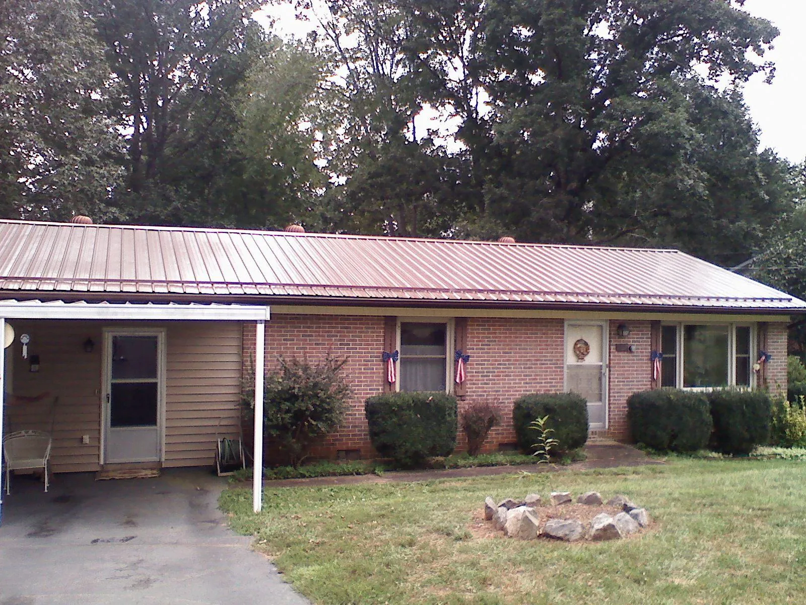 Bronze metal roof and carport on a brick ranch home — Roof Repair work by our crew in Osterville